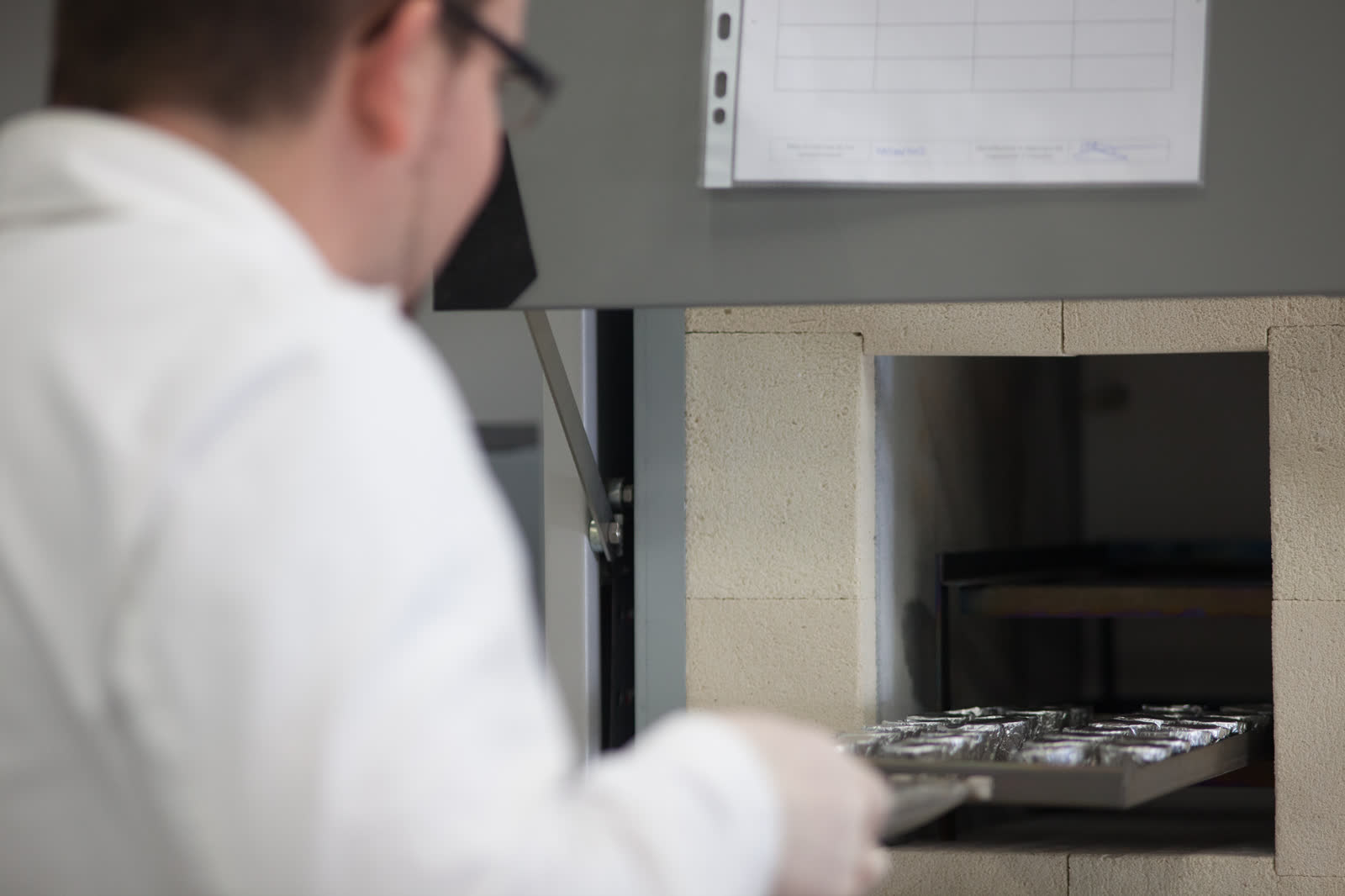 Technician placing samples into a high-temperature laboratory furnace